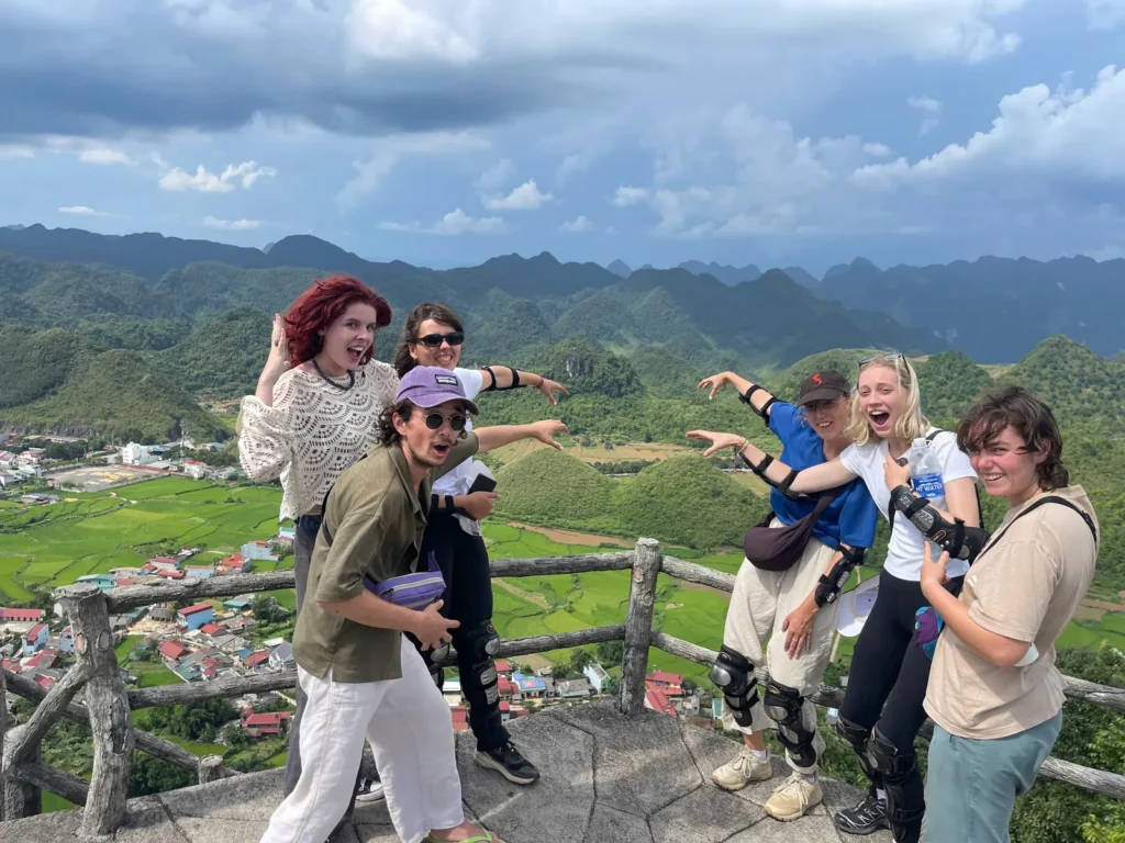 Foreigners taking funny pose with Twin moutains in Ha Giang